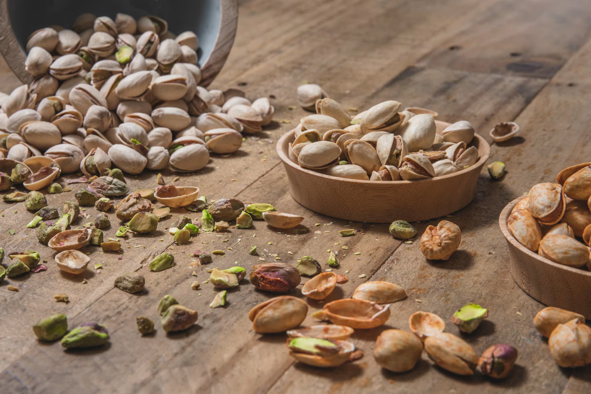 Pistaches renversées de bols en bois sur une table